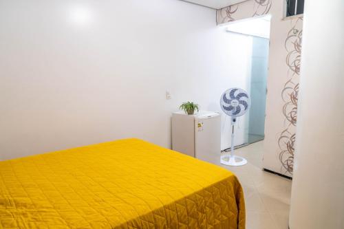 维索萨-杜塞阿拉Flat da Vila的一间卧室配有黄色的床和冰箱