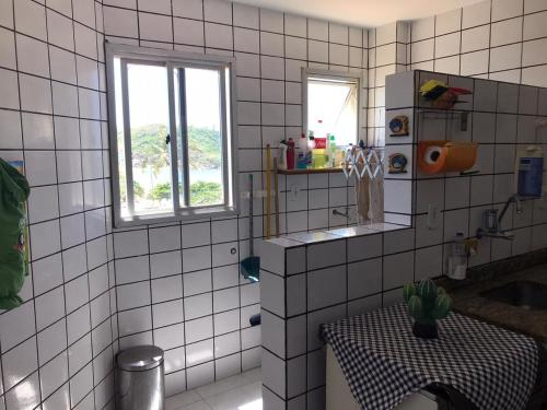 瓜拉派瑞Apartamento a Beira Mar em Setiba Guarapari的白色瓷砖浴室设有桌子和窗户