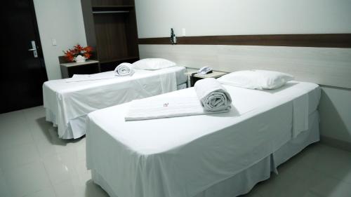 东普里马韦拉Tezla Hotel的配有2张床的客房内配有白色床单和毛巾