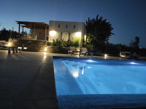 克里希阿克提Andria's suites的夜间在房子前面的游泳池