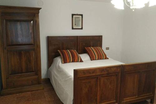 PietramogolanaBorgo Scorza 2的一间卧室配有一张带两个枕头的木床