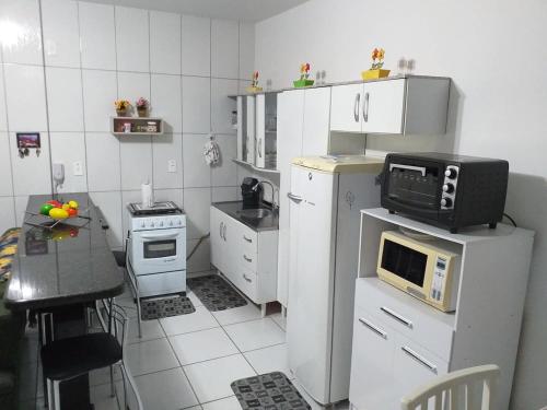 拉古纳Apartamento no Mar Grosso em Laguna SC.的一间带微波炉及冰箱的小厨房