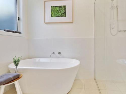 文森提亚Banksia on Blenheim by Experience Jervis Bay的白色的浴室设有浴缸和淋浴。