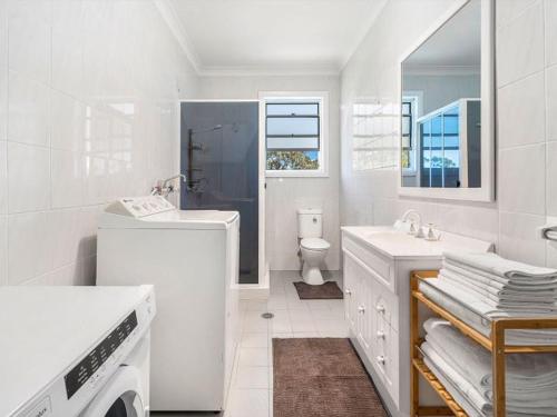 文森提亚Vincentia Breeze by Experience Jervis Bay的白色的浴室设有水槽和卫生间。
