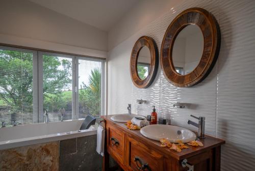 沃克沃思Woodhouse Mountain Lodge的浴室设有两个水槽和两面墙上的镜子