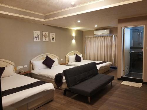 花莲市冠伦饭店的酒店客房,配有两张床和椅子