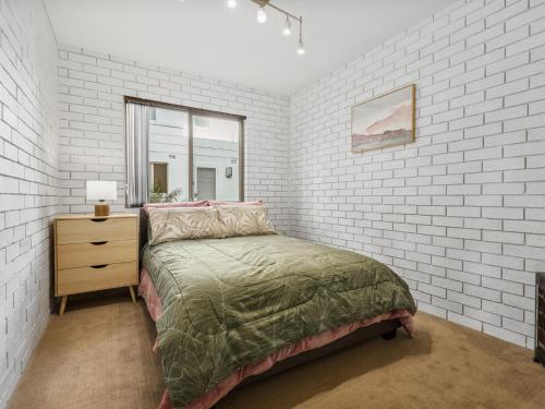 文森提亚Ammos by Experience Jervis Bay的一间卧室设有一张床和砖墙