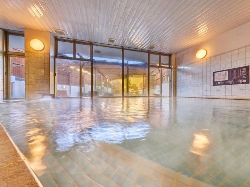 嬉野市Yukai Resort Premium Ureshinokan的一座空的游泳池,位于一座设有玻璃门的建筑中