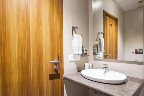 赖布尔Hotel Le Roi Raipur at Raipur Railway Station的一间带水槽和镜子的浴室