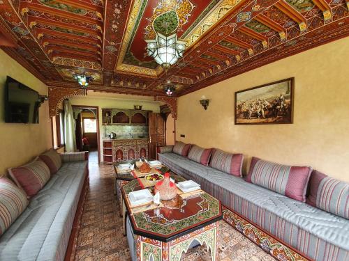 伊姆利尔Dar Assarou - Toubkal National Park Lodge的带沙发和桌子的客厅以及天花板