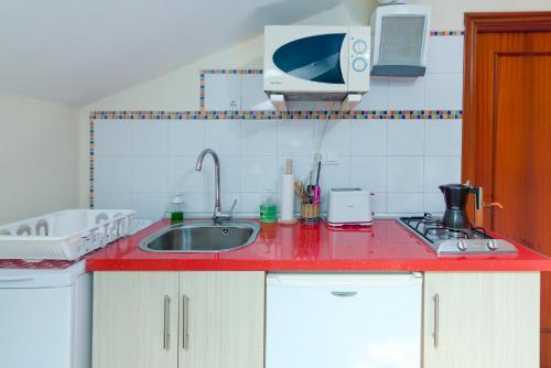 科维达La Casa de Mamasita的厨房配有红色台面和水槽