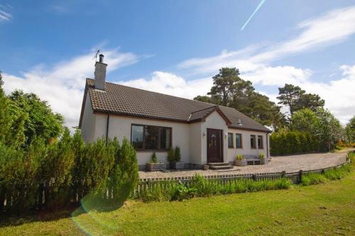 因弗内斯Calm Scottish Country Escape with Hot Tub Sleeps 6的一座白色的小房子,四周有围栏