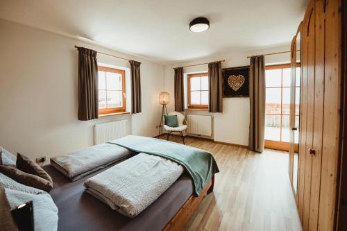 沃兰Apartment Andreas - Gallhof的一间卧室设有两张床、一把椅子和窗户。
