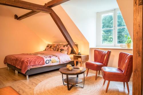 VeenhuizenKlein Soestdijk的卧室配有一张床和一张桌子及椅子