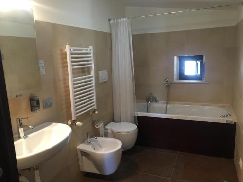 焦维纳佐Hotel Torre Domini的带浴缸、卫生间和盥洗盆的浴室