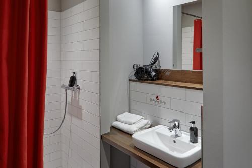 汉堡克罗格温德多格酒店的浴室设有水槽和红色的淋浴帘