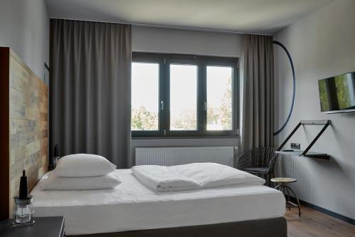 汉堡克罗格温德多格酒店的卧室配有白色的床和窗户。