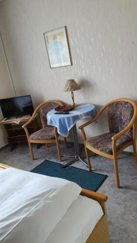 瓦尔德克Pension Backhaus的一间设有两把椅子和一张带台灯的桌子的房间