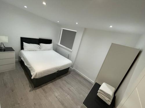 达格纳姆London Dagenham Apartments的一间小卧室,配有床和窗户