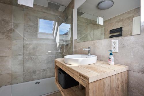 温特贝格Smart Resorts Haus Saphir Ferienwohnung 511的浴室配有盥洗盆、镜子和浴缸