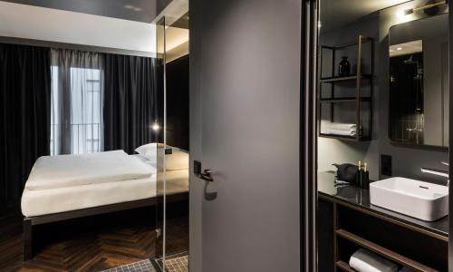 柏林Hotel ROMY by AMANO的一间卧室配有床、水槽和镜子