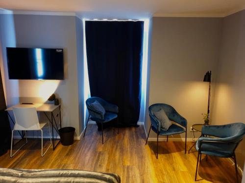 阿恩多夫Hotel Kornblume的客厅配有蓝色椅子和电视