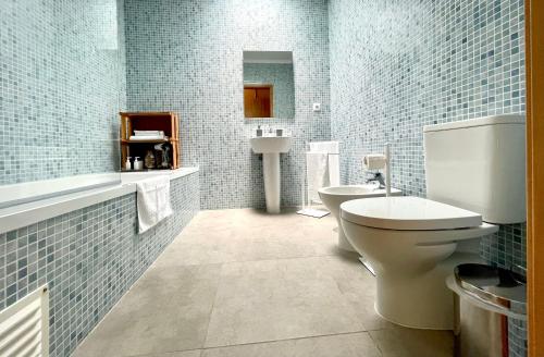 卡佩拉什Solar Pontes的浴室设有卫生间、水槽和蓝色瓷砖。