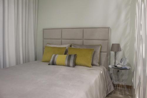 普拉亚达维多利亚Praia Horizonte Studio's - RRAL nº3195的一间卧室配有一张带黄色枕头的大床