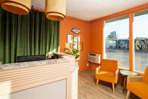 拉斯维加斯Bungalows Hostel的一间办公室,设有橙色墙壁和橙色椅子