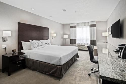 里贾纳Home Inn & Suites Regina Airport的配有一张床和一张书桌的酒店客房