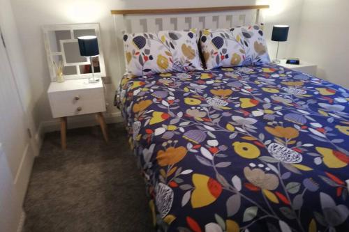 布什米尔斯Mews Apartment, Bushmills的一间卧室配有一张带五颜六色棉被的床