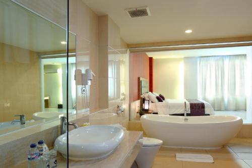 马塔兰龙目岛广场酒店及会议中心的浴室配有大型白色浴缸和水槽