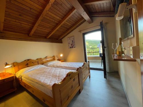 布雷佐内加尔达Hotel Monte Baldo的一间卧室设有一张大型木床和一个阳台。