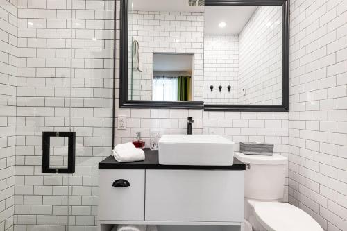 魁北克市家乐德布瓦旅馆的白色的浴室设有水槽和卫生间。