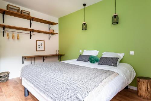 安德诺莱斯贝恩Frenchyhomes☆villadeluxe☆Plage☆piscine的一间卧室设有一张带绿色墙壁的大床