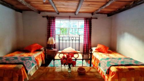MarcaráCasa de Campo Villa Marcara的客房设有两张单人床和一扇窗户。