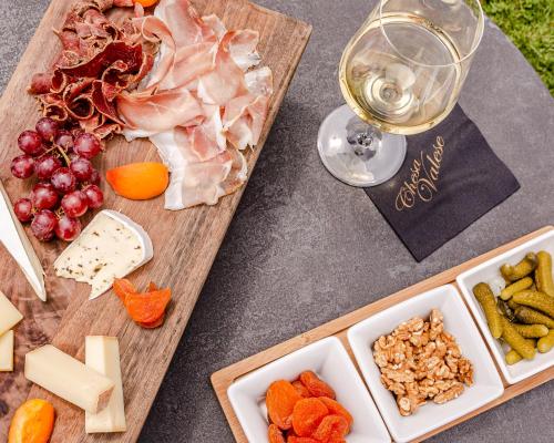 采尔马特赛西亚瓦里塞酒店的一张桌子,上面放着奶酪和肉,还有一杯葡萄酒