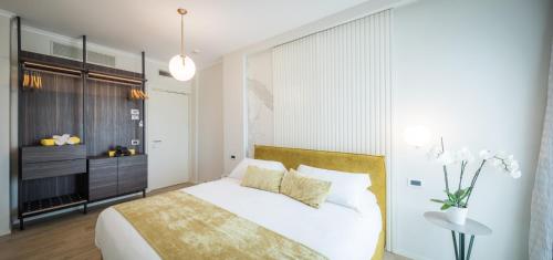 马里纳迪马萨卢纳酒店的卧室配有白色的床和桌子