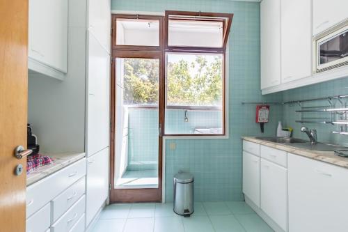 波尔图Pasteleira Relaxing Apartment的厨房设有水槽和窗户。