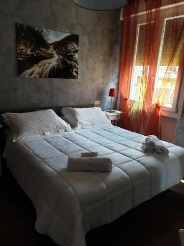 法纳诺hotel Bologna的卧室配有带毛巾的大型白色床