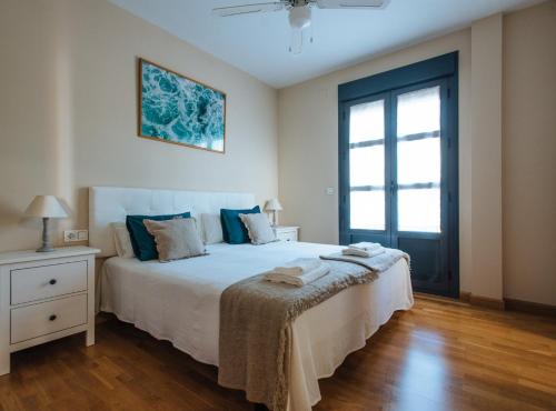 塞维利亚Torneo Suite Apartment的卧室设有一张白色大床和一扇窗户。