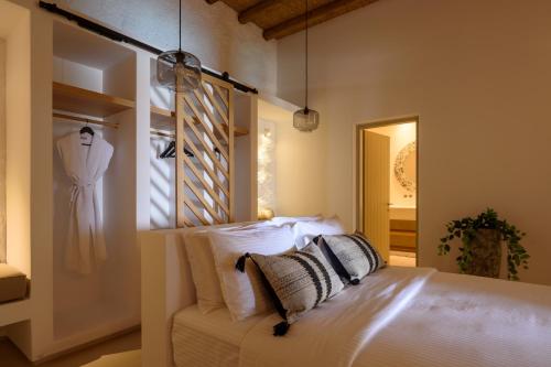 费拉Este Luxury Suites的一间卧室,配有一张床,墙上挂着一连串连衣裙