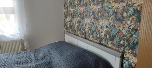 施瓦岑贝格Ferienwohnung Dick Schwarzenberg的卧室,墙上挂着一幅画,床边是