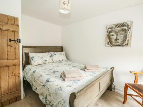 林肯Apple Tree Cottage的一间卧室配有一张带木制床头板的床