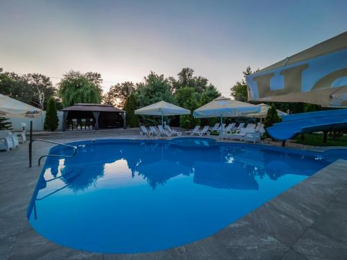 TiszaugClub Hotel Pegasus的一个带椅子和遮阳伞的大型蓝色游泳池