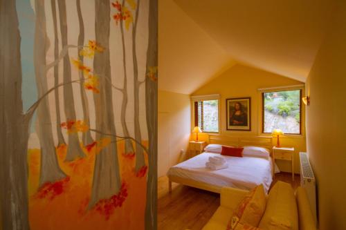 普拉特斯Persephone Cottage by AgroHolidays的一间卧室配有床和树壁画