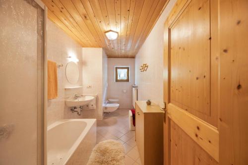 萨伦蒂诺Wieserhof Ferienwohnung Zirm的带浴缸、盥洗盆和卫生间的浴室