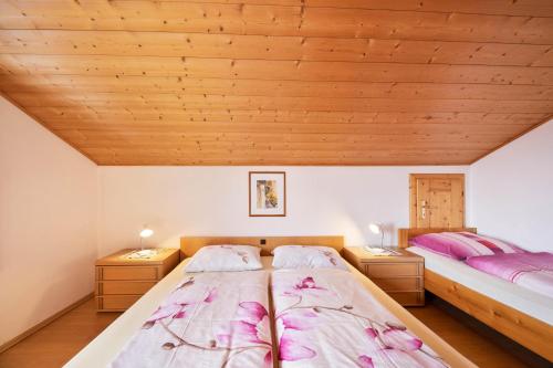 萨伦蒂诺Wieserhof Ferienwohnung Priml的配有木天花板的客房设有两张床。