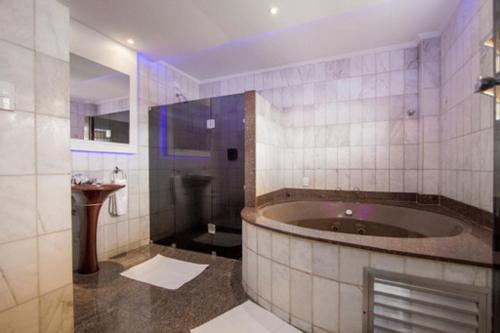 桑托斯Carícia Hotel (Adult Only)的一间带大浴缸和水槽的浴室