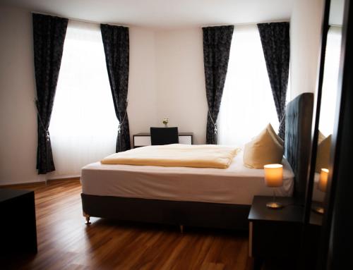 康斯坦茨维森塔勒尔伽尼酒店的一间卧室设有一张床和两个大窗户